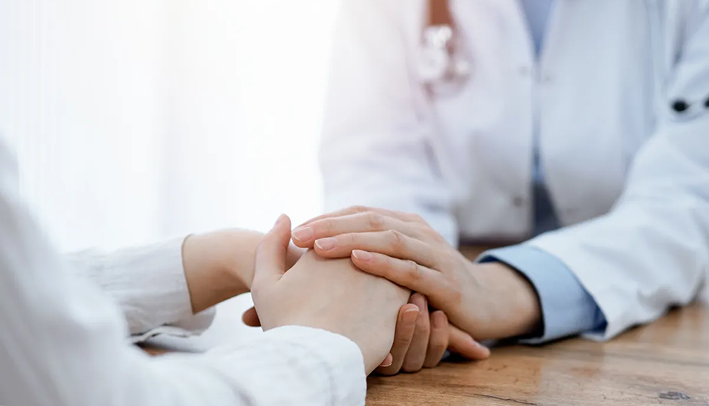 Doctor holding patient's hand with care